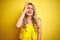 Young attactive woman wearing t-shirt standing over yellow  background doing ok gesture with hand smiling, eye looking