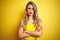 Young attactive woman wearing t-shirt standing over yellow isolated background skeptic and nervous, disapproving expression on