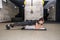 Young attractive and active girl workout plank exercise in the gym for strength and conditioning with barbell weight plate on her