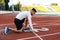 Young attractive African American sportsman preparing for running on racetrack at stadium