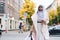 Young attractive Arabic woman in hijab walking through city with shopping bags and coffee
