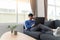 Young attractive asian man relaxing comfortably working on laptop in bright living room at his home