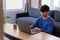 Young attractive asian man relaxing comfortably working on laptop in bright living room at his home