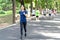 Young attractive asian runner woman running in urban public nature park in city wearing blue or black sporty sportswear with copy