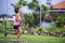 Young attractive Asian sport runner woman running in the jungle smiling happy in training workout on herb with palm young attracti