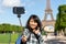 Young attractive asian tourist in Paris taking selfie