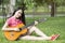 Young attractive asian woman playing acoustic guitar