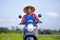 Young attractive backpacker tourist afro American black woman riding motorbike with Asian traditional hat happy along green rice f