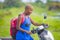 Young attractive backpacker tourist afro American black woman riding motorbike happy in beautiful Asia countryside along green ric