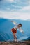 A young, attractive ballerina dancing with a beautiful cloudy sky in the background