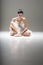 Young attractive ballerina sitting on the floor working with her pointed ballet shoes