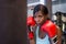 Young attractive and beautiful determined black afro American woman in gym training sweaty on heavy bag punching with boxing glove