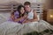 Young attractive and beautiful mix ethnicity happy couple with Asian Korean woman and Caucasian man lying in bed cuddling sweet us