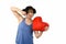 Young attractive and beautiful woman punching in rage spiteful and resentful a red heart shape pillow