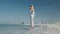 Young attractive blonde girl does yoga on the beach against the backdrop of skyline. Dubai Arabian Emirates