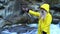 Young attractive blonde girl in yellow raincoat making selfie at the waterfall in mountains nature ecology student youth