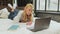 Young attractive blonde woman studying using a laptop while lying on bed. College or high school girl studies at home