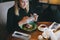 Young attractive blonde woman uses phone at dinner in restaurant