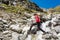 Young attractive brunette crossing a glacier stream in the mountains.