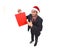 Young attractive businessman in Christmas Santa hat holding and pointing red shopping bag in December and New year sale