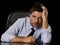 Young attractive businessman in worried tired and stressed face expression sitting depressed on office chair