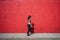 Young attractive Caucasian female with tattoos standing against a red wall