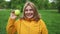 Young attractive Caucasian woman eat green apple fruit outdoors at city spring park. Beautiful active female stand with