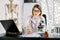 Young attractive Caucasian woman scientist in white coat and eyeglasses in the scientific medical chemical laboratory