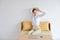 Young attractive caucasian woman wearing white casual clothes enjoying in stretching with relaxation on sofa in bedroom or living