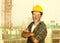 Young attractive and confident contractor or construction worker man with builder safety helmet posing corporate smiling cheerful