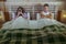 Young attractive couple in bed with social media addict woman using internet mobile phone ignoring frustrated and upset man moody