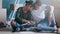 Young attractive couple choosing colors in a color palette to paint the walls of the apartment while sitting on the floor