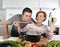 Young attractive couple at home kitchen with man tasting vegetable stew cooked by her wife smiling happy