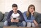 Young attractive couple in relationship problem with internet mobile phone addiction boyfriend ignoring sad neglected and bored gi