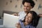 Young attractive diverse couple browsing internet, using laptop computer, smiling.