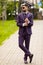 Young attractive executive businessman wearing on violet luxery three-piece suit standing outdoors on street dressing for success