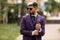 Young attractive executive businessman wearing on violet luxery three-piece suit standing outdoors on street dressing for success