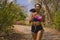 Young attractive and exotic Asian Indonesian runner woman in jogging workout outdoors at countryside road track nature running