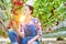 Young attractive female farmer picking tomatoes in greenhouse with yellow lens flare