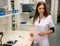 Young attractive female pharmacy employee holds paper with medical information in a pharmacy