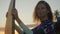 Young attractive female surfer smiling and posing with her surfboard at sunset on the beach