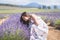 Young attractive female with a white dress is posing for the camera in the Lavanda field