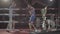 Young attractive fighter male boxer athlete training workout practicing punch hook kick with personal coach boxing ring