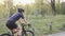 Young attractive fit woman riding a bicycle in the park. Training for a race. Cycling concept. Slow motion