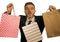 Young attractive and funny business man or shopaholic in suit and tie holding shopping bags with hands and teeth playful in sales