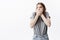 Young attractive funny dark-haired caucasian student girl in stylish grey t-shirt and jeans looking aside with shocked