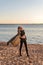 A young attractive girl with bare abdominal muscles strolls along the beach promenade with flying cape in the rays of the setting