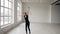 Young attractive girl in black body performs training a gymnastics exercise with a hoop in the gymnastic school on white