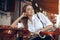 Young attractive girl with close eyes in white shirt with a saxophone sitting in caffe shop - outdoor in sity. young woman wi