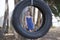 A young attractive girl playing with a tyre swing